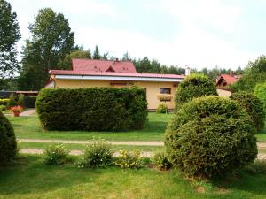 a house with bushes in front of a yard at Dom wczasowy Fala w Kopalinie in Lubiatowo