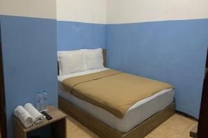 een slaapkamer met een bed met een blauwe muur bij Bright Batavia in Jakarta