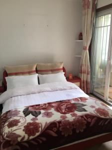 1 dormitorio con 1 cama con colcha de flores en 雅伦之屋 Yailon Aparment, en Nanjing