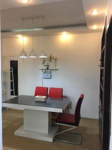 una sala da pranzo con 2 sedie rosse e un tavolo di Yailon House - TieXinQiao Metro St-ation - NanJing South Railway St-ation - 雅伦之屋-铁心桥地铁站-火车南站店 a Nanjing