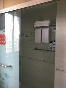 una doccia con una porta in vetro in un bagno di Yailon House - TieXinQiao Metro St-ation - NanJing South Railway St-ation - 雅伦之屋-铁心桥地铁站-火车南站店 a Nanjing