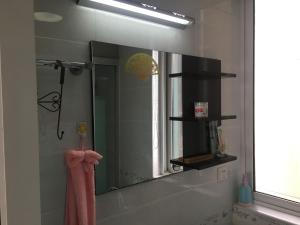 einen Spiegel im Bad mit einem rosa Handtuch in der Unterkunft 雅伦之屋 Yailon Aparment in Nanjing