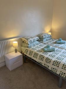 two twin beds in a room with a night stand at Above The Pub in Alvechurch