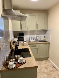 a kitchen with white cabinets and a counter top at Above The Pub in Alvechurch