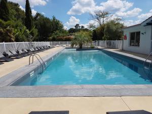 a swimming pool with chairs and a white fence at Camping le Marache in Biganos +23 photos