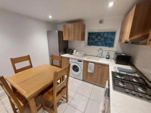 a kitchen with a wooden table and a dining room at Cosy London Family apartment for 4 persons near Westfield Shepherd's Bush in London
