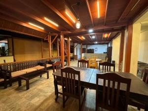 a dining room with benches and a table and chairs at MC Bunaken Inn & Dive in Bunaken