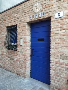 una puerta de garaje azul en un edificio de ladrillo en Trilocale vista mare con 2 bagni nel centro storico - Agenzia Cocal, en Caorle 5 fotos más