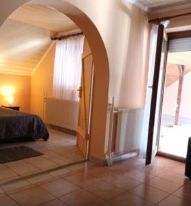 1 dormitorio con 1 cama y puerta abierta en Villa Miranda, en Siófok