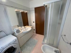a bathroom with a sink and a shower and a washing machine at Trilocale vista mare con 2 bagni nel centro storico - Agenzia Cocal in Caorle