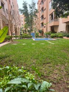 um parque com piscina no meio de um edifício em Appartement safran avec piscine em Marraquexe