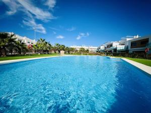 uma grande piscina com água azul em frente aos edifícios em Vanillla em Orihuela