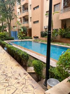 una piscina di fronte a un edificio di Appartement safran avec piscine a Marrakech