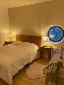 1 dormitorio con cama y ventana redonda en Charmant T3 à côté des Thermes en Luxeuil-les-Bains