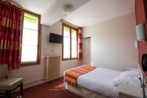 een hotelkamer met een bed en twee ramen bij Hôtel Chez MiMi in Bar-sur-Seine