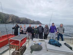 a group of people standing on a boat at Burtonport fishing trips in Dungloe