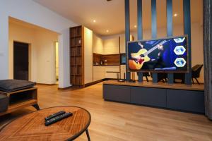 sala de estar con TV con guitarra en Hotel Apartments Ardi & Lala, en Peje