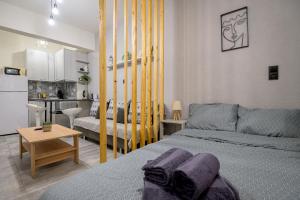 - une chambre avec un lit et un salon dans l'établissement CityScape Studio, à Alexandroúpolis