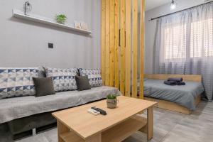 - un salon avec un canapé et un lit dans l'établissement CityScape Studio, à Alexandroúpolis