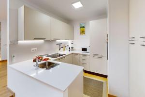 eine weiße Küche mit weißen Schränken und einer Spüle in der Unterkunft Can Xec - casa reformada Pals in Pals