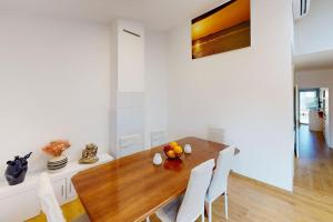 ein Esszimmer mit einem Holztisch und weißen Wänden in der Unterkunft Can Xec - casa reformada Pals in Pals + 10 Fotos