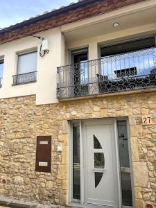 ein Steingebäude mit einem Balkon und einer weißen Tür in der Unterkunft Can Xec - casa reformada Pals in Pals