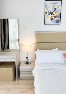 - une chambre avec un lit et une table avec une lampe dans l'établissement 4pax Harbour Front Hotel Style, à Nusajaya