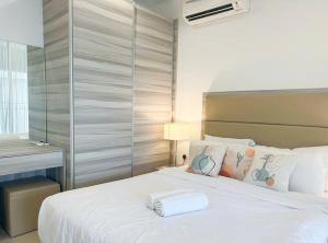 - une chambre avec un lit blanc et une serviette blanche dans l'établissement 4pax Harbour Front Hotel Style, à Nusajaya