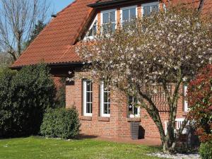 a brick house with a tree in front of it at Wohlfühlhaus, hell und modern in Wardenburg