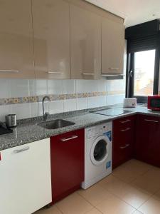 cocina con lavadora y fregadero en Apartamento en Gijon, en Gijón