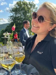 a woman sitting at a table with glasses of wine at stuub hinterzarten in Hinterzarten