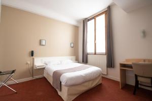 een slaapkamer met een bed, een bureau en een raam bij Hôtel Chez MiMi in Bar-sur-Seine