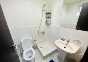 a white bathroom with a toilet and a sink at STA Homes Dubai in Dubai