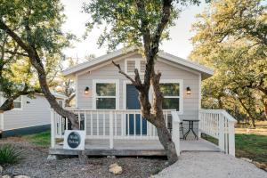 a tiny house with a porch and a tree at Step Free Entrance-Wolfe Cottage at Wrenwood Ranch, King Bed in Johnson City