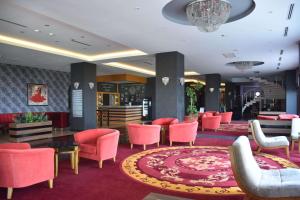 vestíbulo del hotel con sillas rosas, mesa y alfombra en Ramada by Wyndham Tekirdağ, en Tekirdağ