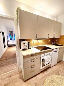 a kitchen with white cabinets and a stove top oven at Apartment 1 Hamburg Winterhude in Hamburg