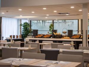 a restaurant with tables and chairs and a buffet at Mercure Paris Centre Tour Eiffel in Paris