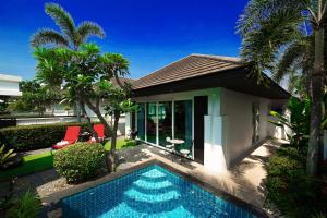 una casa con piscina frente a una casa en Villas In Pattaya, en Jomtien Beach