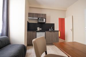 een kleine keuken met een tafel en een magnetron bij Hôtel Chez MiMi in Bar-sur-Seine +27 foto's