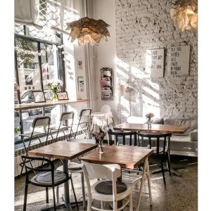 a restaurant with wooden tables and chairs in a room at Centrum Szkoleniowo-Konferencyjne Społem in Warsaw