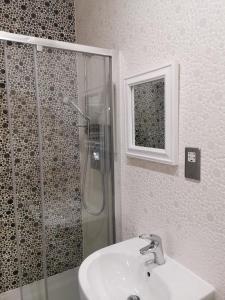 a bathroom with a glass shower and a sink at Riverside Cockatoo's Cottage Charming 3 Bed Retreat for up to 10 Guests in Stockton-on-Tees