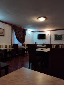 Vila Rakoč في كولاسين: غرفة طعام بها طاولات وكراسي وتلفزيون