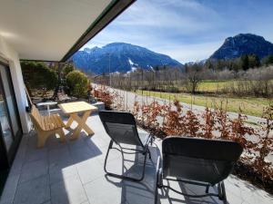 un patio con 2 sedie, un tavolo e le montagne di Ferienwohnung Bergnah a Pfronten
