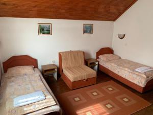 Habitación con 2 camas y una silla. en Vila Rakoč, en Kolašin