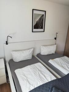 two beds in a room with a picture on the wall at private Ferienwohnung Senftenberg in Sedlitz