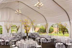 a white tent with tables and chairs and chandeliers at Hyatt Regency Boston/Cambridge in Cambridge