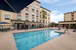 a pool at a hotel with chairs and a building at Hampton Inn & Suites Phoenix North/Happy Valley in Phoenix