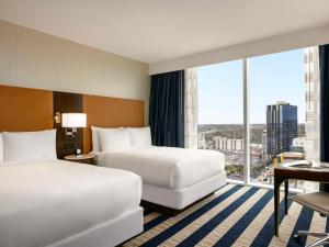 um quarto de hotel com duas camas e uma grande janela em Fairmont Austin em Austin