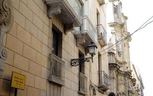 a building with balconies and a street sign on it at Appartamento Alla Corte dei Misteri in Trapani