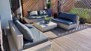 a patio with chairs and couches on a deck at Chill Haus mit Sauna und Kamin in Groß Kreutz
